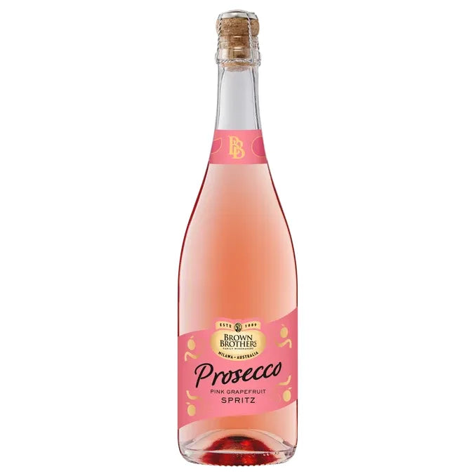 A bottle of Brown Brothers Prosecco Pink Grapefruit Spritz, featuring a light pink liquid, a pink label with gold and black text, and a corked neck, isolated on a white background.