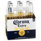 Six-pack of Corona Extra beer bottles in a cardboard holder on a white background