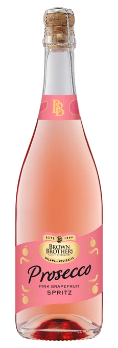 A bottle of Brown Brothers Prosecco Pink Grapefruit Spritz, featuring a light pink liquid, a pink label with gold and black text, and a corked neck, isolated on a white background.
