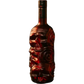 A dark glass bottle with an intricate carved skull and floral design on the front, filled with a deep red liquid, shown against a plain white background.